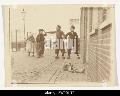 Children in traditional costume in Volendam, in the foreground some clogs, c. 1900 - c. 1910 photograph  Volendam photographic support salted paper print child. folk costume, regional costume Volendam Stock Photo