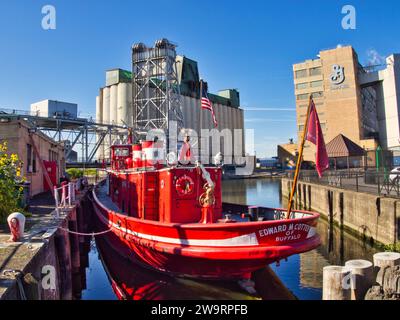 Edward M. Cotter fireboat anchored in Buffalo, NY, in front of General Mills factory and industrial waterfront of Buffalo. Stock Photo