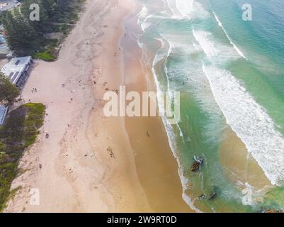 Aerial view of waves rolling onto a wide sandy beach at Tathra on the South Coast of New South Wales in Australia Stock Photo