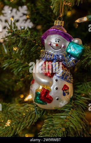 Close up view of a colorful retro style hanging glass Christmas tree ornament depicting a jolly snowman Stock Photo