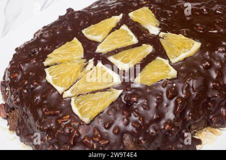 Extreme close-up of triangular orange segments atop the chocolate and almond texture of a cocoa cake. Texture and flavors. Stock Photo