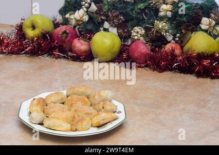 A festive plate of homemade almond marzipans, along with Christmas decorations and fruits and copy space on the countertop, captures the spirit of the Stock Photo