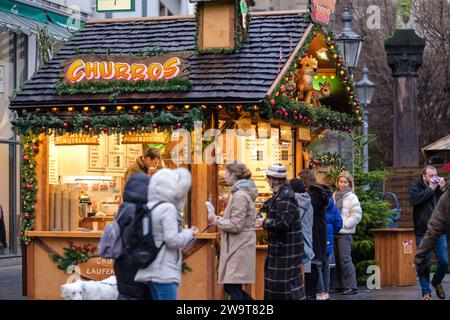 Bonn, Germany - December 17, 2023 : View of a small food stand selling Churros and other candies at the Christmas Market in Bonn Germany Stock Photo