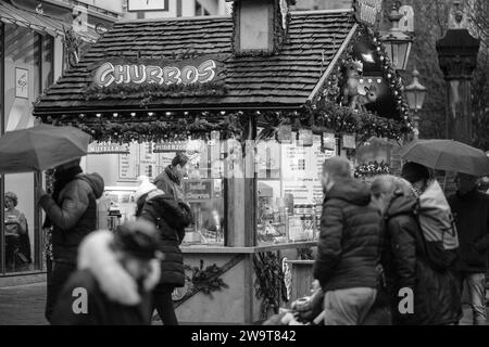 Bonn, Germany - December 17, 2023 : View of a small food stand selling Churros and other candies at the Christmas Market in Bonn Germany Stock Photo