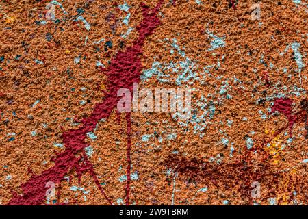 White plastered wall splattered with red paint. Paint splashes on the wall. Painted plaster wall. Abstract background. Painted plaster texture. Stock Photo