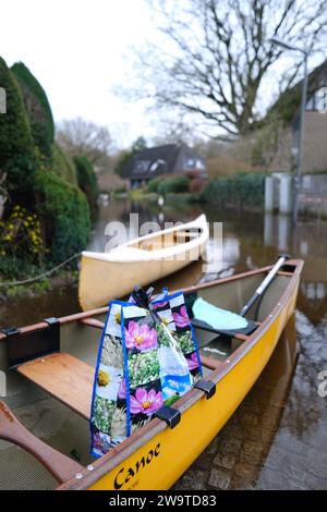 Borgfeld, Germany. 30th Dec, 2023. Canoes stand on a flooded street in Borgfeld near Bremen. The River Wümme has burst its banks here. Residents can only reach their homes by boat. Credit: Markus Hibbeler/dpa/Alamy Live News Stock Photo