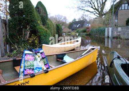 Borgfeld, Germany. 30th Dec, 2023. Canoes stand on a flooded street in Borgfeld near Bremen. The River Wümme has burst its banks here. Residents can only reach their homes by boat. Credit: Markus Hibbeler/dpa/Alamy Live News Stock Photo