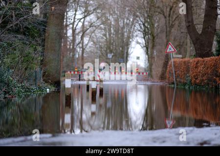 Borgfeld, Germany. 30th Dec, 2023. A street in Borgfeld near Bremen is under water. The Wümme river has burst its banks here. Credit: Markus Hibbeler/dpa/Alamy Live News Stock Photo