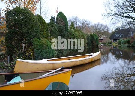 Borgfeld, Germany. 30th Dec, 2023. Canoes stand on a flooded street in Borgfeld near Bremen. The River Wümme has burst its banks here. Residents can only reach their homes by boat. Credit: Markus Hibbeler/dpa/Alamy Live News Stock Photo