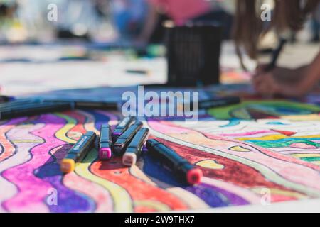 Process of drawing on asphalt and pavement, kids and children with crayons, chalk and markers, teens creating street art on the ground, graffiti and p Stock Photo