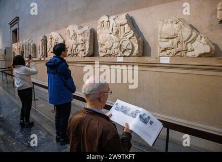 London, UK. 30th Dec, 2023. Visitors at the British Museum view ancient sculptures in the Parthenon Galleries. They are also referred to as The Elgin Marbles after Lord Elgin took them to London between 1801 and 1812. Tony Blair considered loaning them to Greece as an idea to boost Londons bid for the 2012 Olympics. One idea being proposed is Greece could organise rotating exhibitions of some of its most important artefacts to replace the Parthenon Marbles, were they to be returned to Athens, the Greek Culture minister said. Credit: Mark Thomas/Alamy Live News Stock Photo