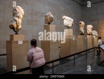 London, UK. 30th Dec, 2023. Visitors at the British Museum view ancient sculptures in the Parthenon Galleries. They are also referred to as The Elgin Marbles after Lord Elgin took them to London between 1801 and 1812. Tony Blair considered loaning them to Greece as an idea to boost Londons bid for the 2012 Olympics. One idea being proposed is Greece could organise rotating exhibitions of some of its most important artefacts to replace the Parthenon Marbles, were they to be returned to Athens, the Greek Culture minister said. Credit: Mark Thomas/Alamy Live News Stock Photo