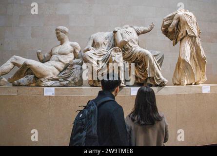 London, UK. 30th Dec, 2023. Visitors at the British Museum view ancient sculptures in the Parthenon Galleries. They are also referred to as The Elgin Marbles after Lord Elgin took them to London between 1801 and 1812. Tony Blair considered loaning them to Greece as an idea to boost Londons bid for the 2012 Olympics. One idea being proposed is Greece could organise rotating exhibitions of some of its most important artefacts to replace the Parthenon Marbles, were they to be returned to Athens, the Greek Culture minister said. Credit: Mark Thomas/Alamy Live News Stock Photo