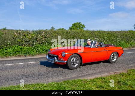 1974 70s seventies MG B Orange Car Petrol 1800 cc cabrio; Vintage restored classic specialist motors vehicle restoration, automobile collectors, yesteryear motoring enthusiasts and historic veteran cars travelling in Cheshire, UK Stock Photo