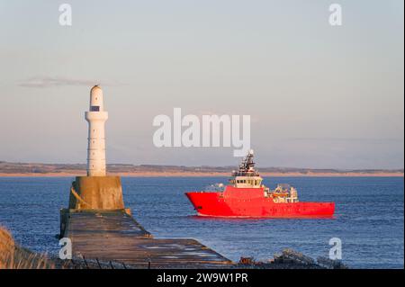 Ship arriving at Aberdeen harbour after passing Girdle Ness Lighthouse Stock Photo
