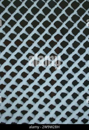 Pattern background of snow patterns on a metal grid Stock Photo