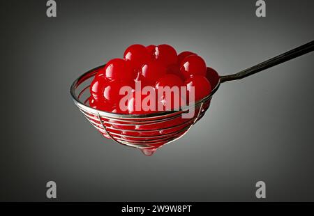 red jelly balls for making bubble tea in a strainer on grey background Stock Photo