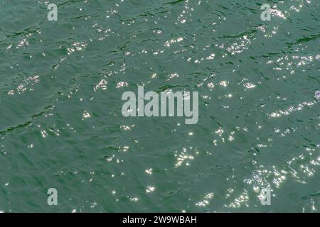 River from above, ocean water surface aerial view, water texture background, light blue green reflection on lake wave ripples flat surface. Sun light Stock Photo