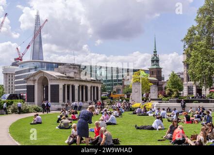 Tower Hill, London, UK - June 19th 2012: People relaxing in Trinity Square Gardens. In the background are the Tower Hill Memorials. Stock Photo