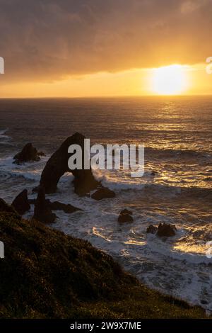 Sunset over the waves on the sea and the jetty from the beach with ...