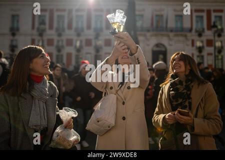 A group of women toasts as they celebrate the arrival of a new year in the Plaza de la Puerta del Sol. Like every December 30, hundreds of people have celebrated the beginning of the new year in advance. As a tradition, in Madrid families and friends have celebrated by drinking New Year's grapes. Stock Photo