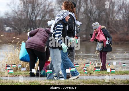 Harrisburg, United States. 30th Dec, 2023. People place small Palestinian flags in the ground along Front Street in Harrisburg Pa. on December 30, 2023. Demonstrators placed more than 20,000 flags, one for each person killed in Gaza since the beginning of the Israel-Hamas War, along the street near the Pennsylvania Governor's Residence. (Photo by Paul Weaver/Sipa USA) Credit: Sipa USA/Alamy Live News Stock Photo