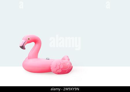 Pink pool plastic inflatable flamingo with light blue background Stock Photo