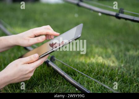 Farmer controls drip irrigation system with digital tablet. Stock Photo