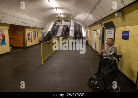 saxophone playing busker with no one around, London Underground, UK Stock Photo