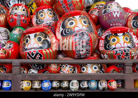 A group of traditional Japanese daruma dolls piled up at Shorinzan Daruma-ji Temple in Gunma Prefecture, Japan. Stock Photo