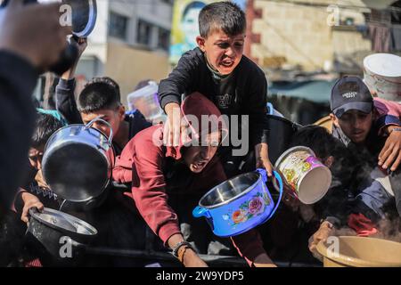 Rafah, Palestinian Territories. 31st Dec, 2023. Palestinian children wait to receive food prepared in a charity kitchen amid a lack of food supplies as the fighting between Israel and Hamas continues. Credit: Mohammed Talatene/dpa/Alamy Live News Stock Photo