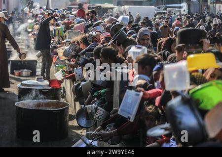 Rafah, Palestinian Territories. 31st Dec, 2023. Palestinians wait to receive food prepared in a charity kitchen amid a lack of food supplies as the fighting between Israel and Hamas continues. Credit: Mohammed Talatene/dpa/Alamy Live News Stock Photo