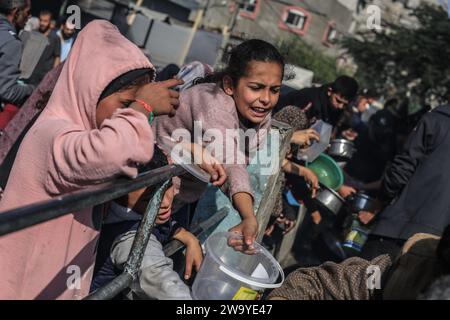 Rafah, Palestinian Territories. 31st Dec, 2023. Palestinian children wait to receive food prepared in a charity kitchen amid a lack of food supplies as the fighting between Israel and Hamas continues. Credit: Mohammed Talatene/dpa/Alamy Live News Stock Photo