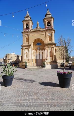 Plants in front of parish church of our lady of pompei, European Marsaxlokk town, Malta, clear blue sky in 2022 hot sunny spring day on May - vertical Stock Photo