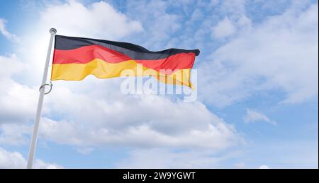 German flag flutters in the wind. State symbol of Federal Republic of Germany.. Stock Photo