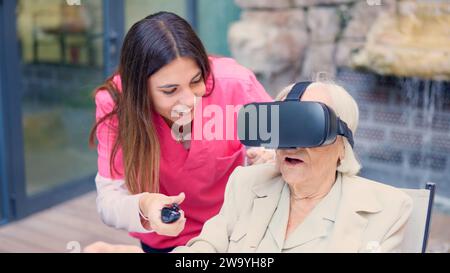Nurse and a senior woman using virtual reality goggles Stock Photo