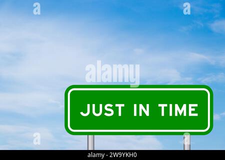Green color transportation sign with word just in time on blue sky with white cloud background Stock Photo