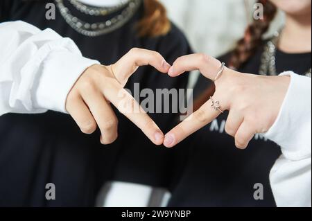 Two girl are friends joined hands and made a heart shape Stock Photo