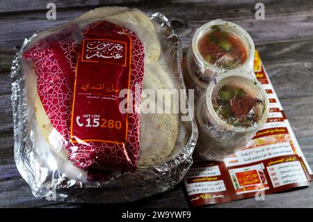 Cairo, Egypt, December 26 2023: Hadramout Antar restaurant Chicken mandi kabsa with long basmati rice, served with tomato dakos sauce, green salad and Stock Photo