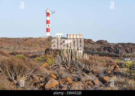 Faro Punta de Rasca, solitary lighthouse nested within the wilderness, between the rugged volcanic terrain covered in the indigenous vegetation Stock Photo