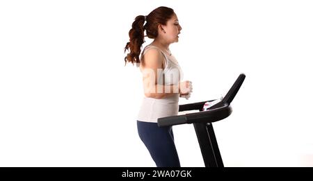 red head woman running on tredmill on a white background Stock Photo