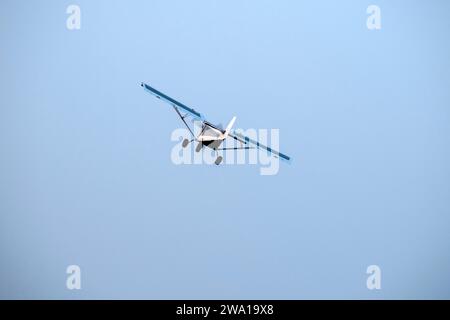 Old propeller plane is flying on isolated blue sky Stock Photo