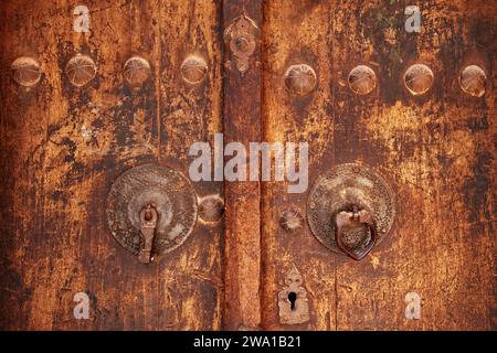 Detail of an old front door with two different knockers - metal bar for men and metal ring for women. Abyaneh village, Natanz County, Iran. Stock Photo