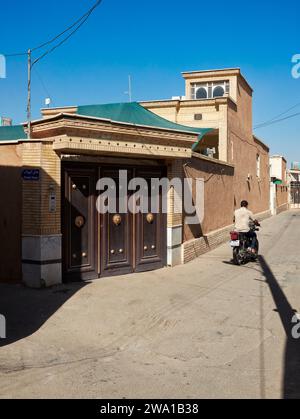 Man on a motorbike rides in a narrow street in the historic center of Kashan, Iran. Stock Photo