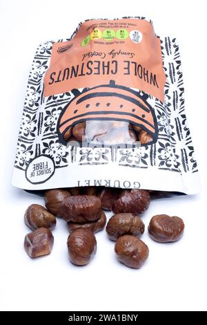 Opened bag of Merchant Gourmet cooked Whole Chestnuts spilling onto a White Surface Stock Photo