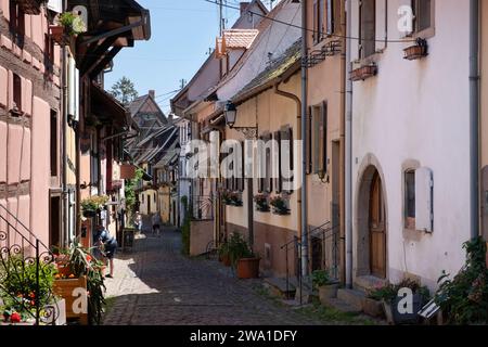 Street with picturesque houses in the medieval village of Eguisheim, on the Alsatian Wine Route Stock Photo