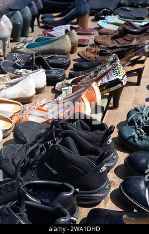 Second-hand women's and men's shoes in all shapes and sizes for sale at a flea market in Maastricht. Focus on the black shoes in the front Stock Photo