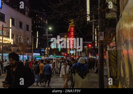 Vancouver, CANADA - Dec 31 2023 : A view of Granville Street on New Year's Eve. Crowds of people are drinking in nightclubs and celebrating New Year Stock Photo