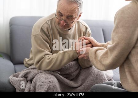 Head shot old male pensioner involved in rehabilitation procedure with caring young physiotherapist. retired man with walking disability feeling Stock Photo