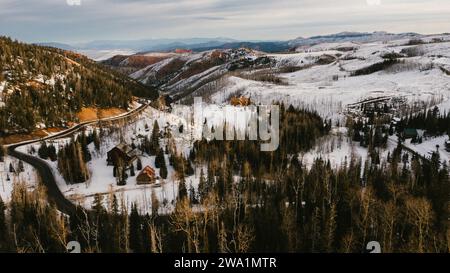 Mountain road going through cabin town in snowy winter scene Stock Photo
